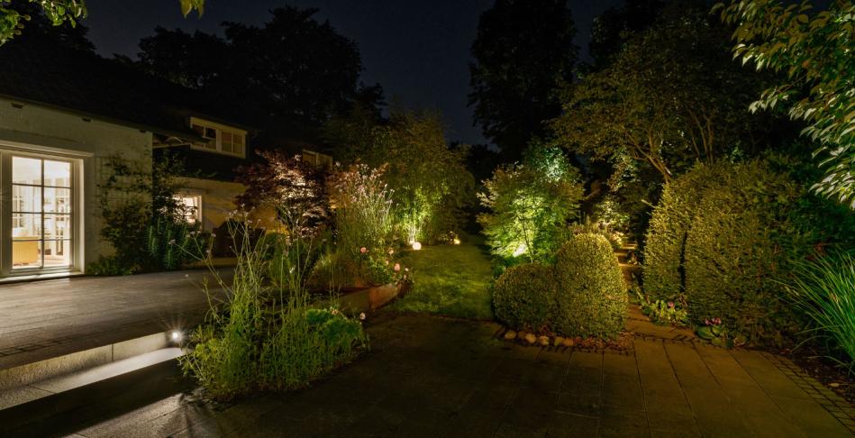 Indirekte Beleuchtung von Hecke, Pflanzen und Büschen in der Nähe der Terrasse.