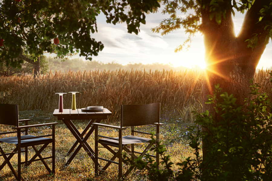 Zwei Lix-Akkuleuchten stehen auf einem Tisch vor einem Weizenfeld im Sonnenuntergang. (Foto: IP44.de)