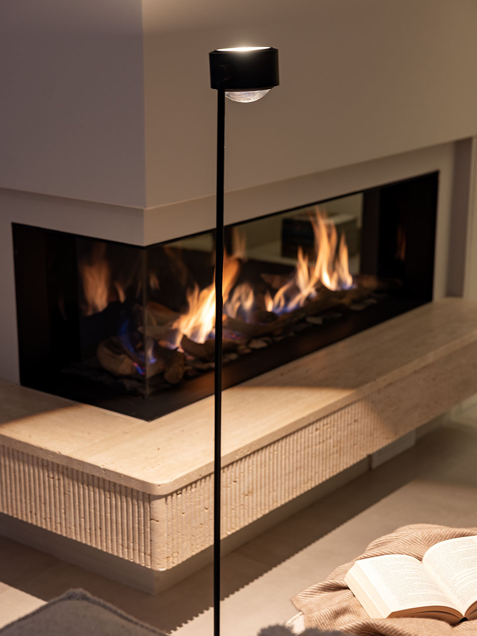 Im Wohnzimmer vor einem Kamin steht eine s.200 Stehleuchte in Schwarz von prediger.select. Das Wohnzimmer ist gemütlich und modern gestaltet.
