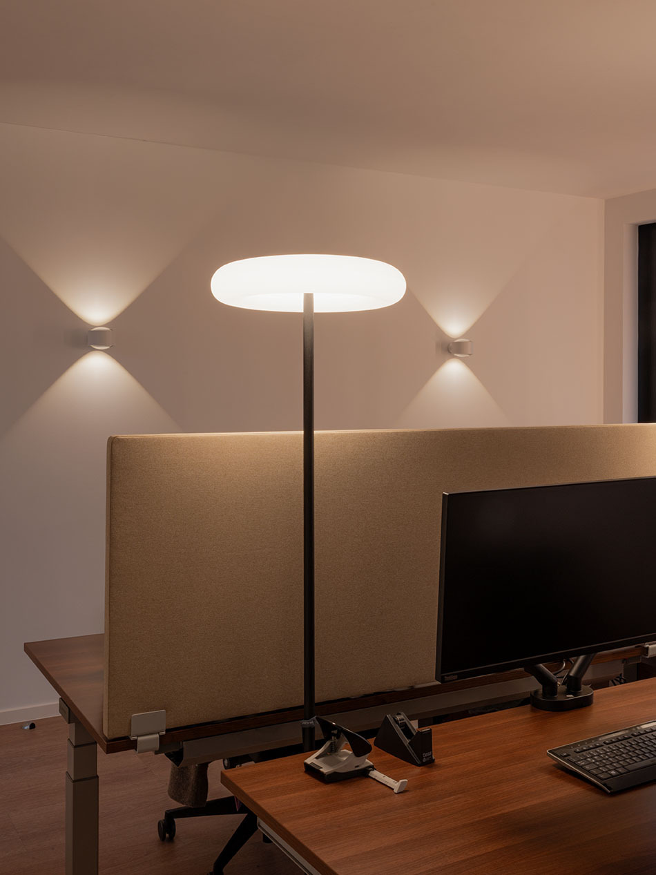 Das Büro wird von zwei p.133 Wandleuchten von prediger.base beleuchtet. Vertikale LED-Wandprofile von Sigor sowie zwei Oto Standleuchten von Belux sorgen für die Allgemeinbeleuchtung.