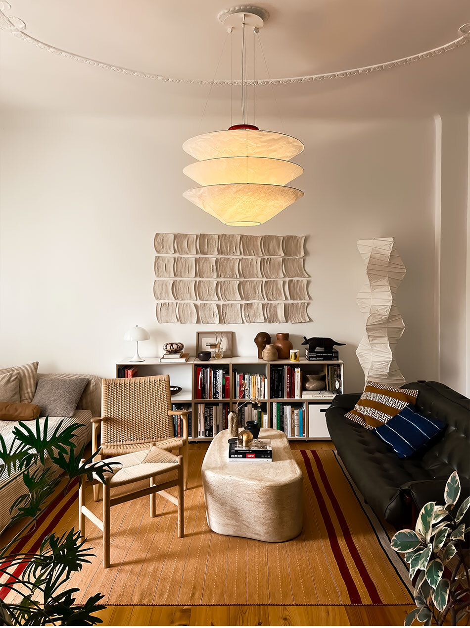 Das Bild zeigt das Wohnzimmer einer Altbauwohnung mit der Floatation Pendelleuchte von Ingo Maurer.