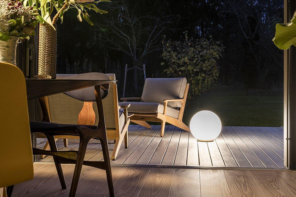 Auf einer Terrasse steht eine p.111 Kugelleuchte von prediger.base. Daneben stehen Outdoor-Stühle.