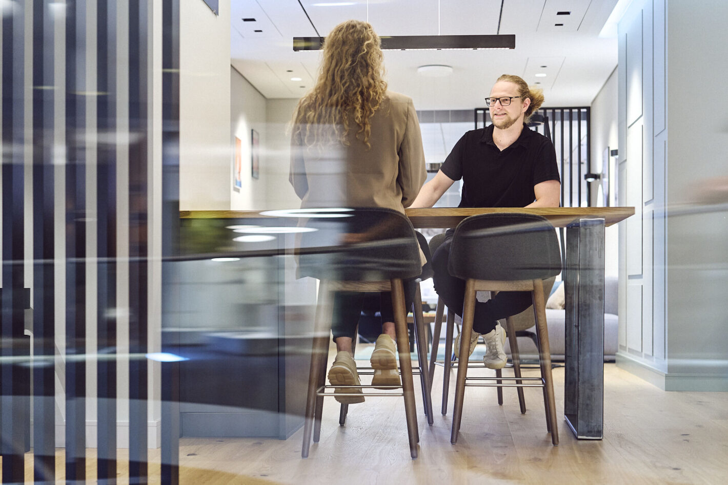 Ein Mitarbeiter von Prediger Lichtberater sitzt an einem Tisch im Showroom und führt eine Besprechung mit einer Kundin. (Foto: Johannes Arlt)