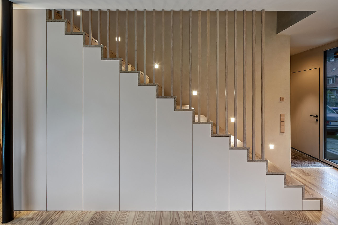 Treppe mit mehreren Heli Einbau-Wandleuchten von Delta Light, die die Treppenstufen beleuchten.