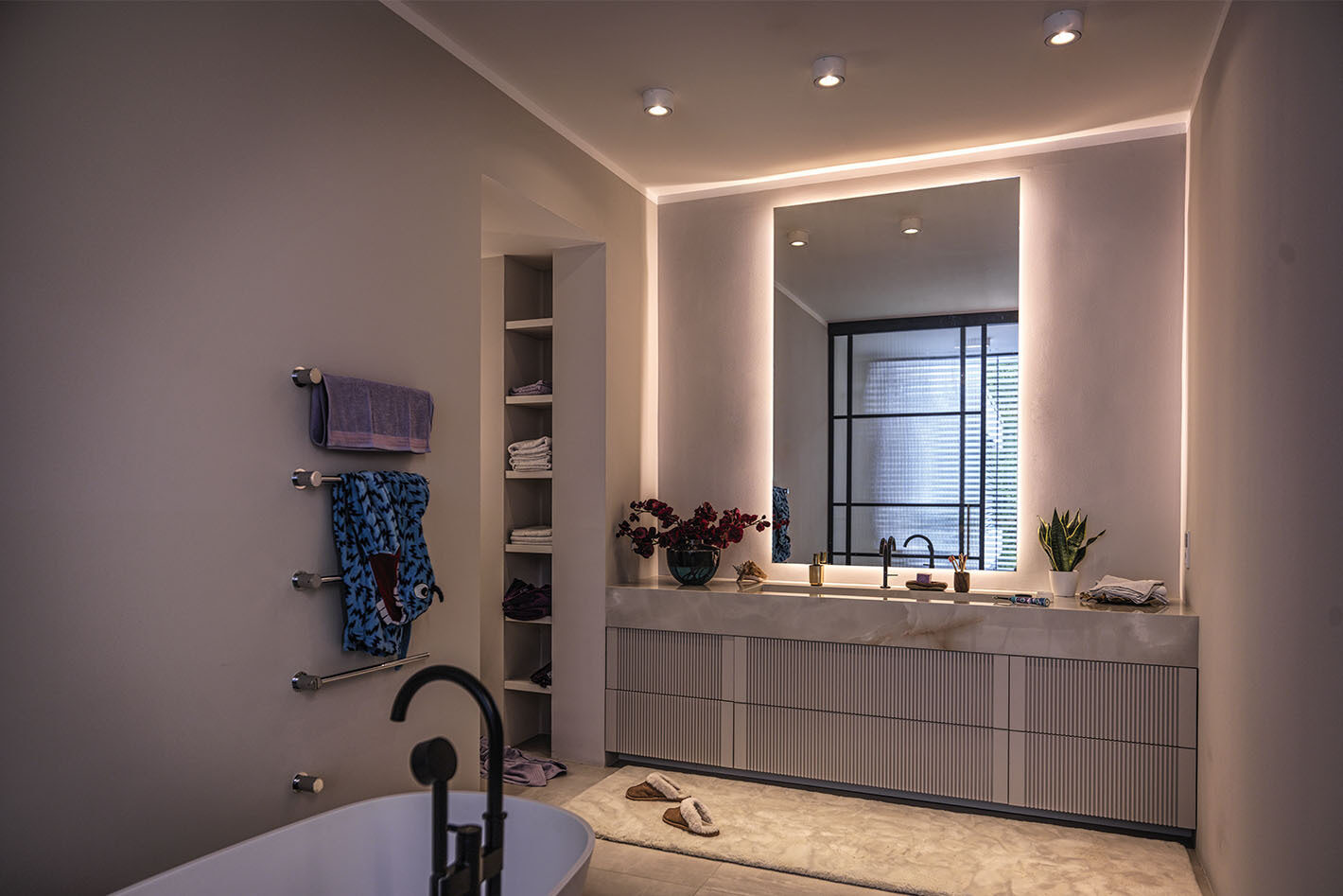 Modernes Badezimmer mit freistehender Badewanne und drei p.132 Deckenleuchten von prediger.base. Der Raum wirkt minimalistisch und elegant gestaltet.