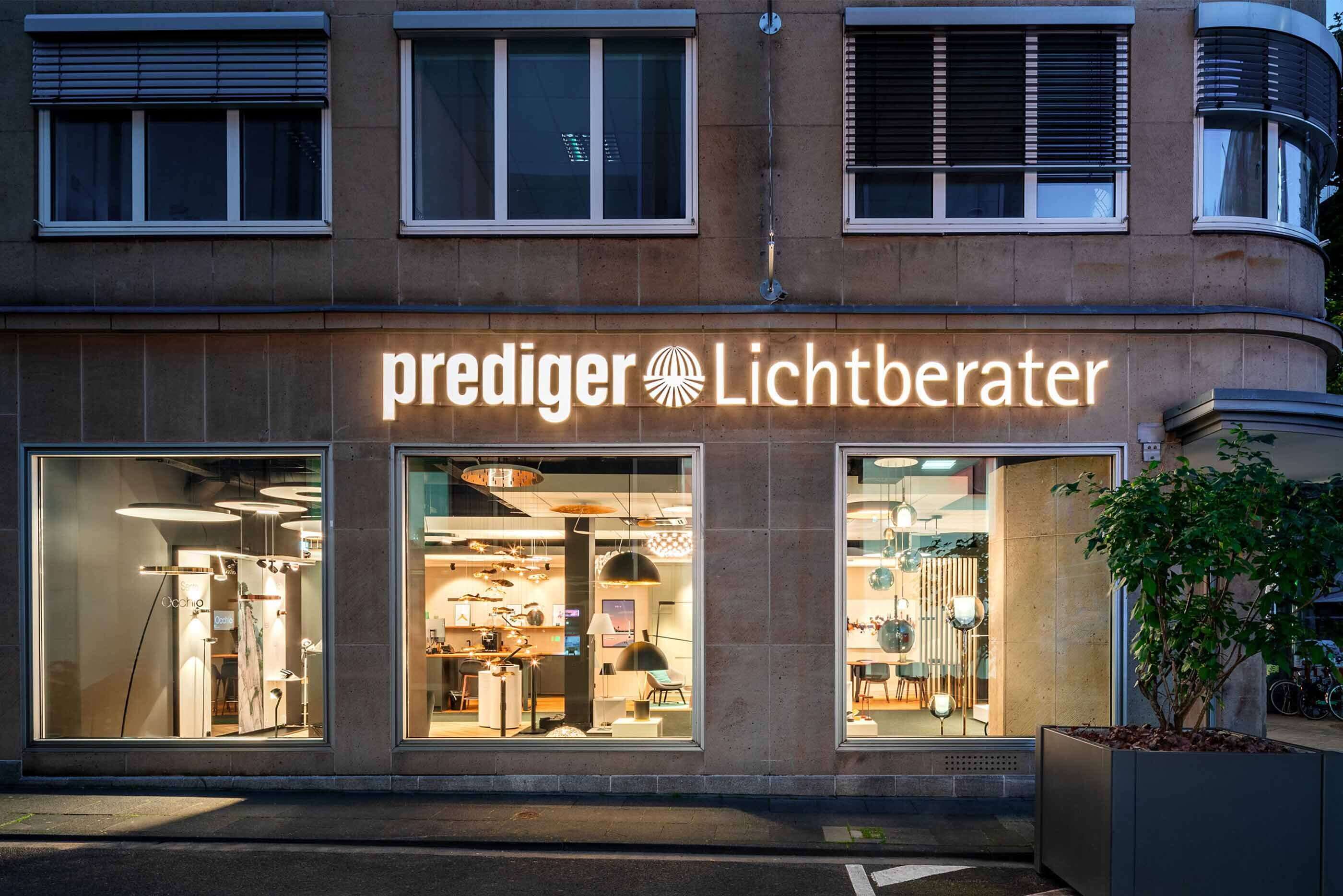 Außenaufnahme bei Abenddämmerung_ Der Showroom Köln wird durch unterschiedliche Leuchten im Innenbereich beleuchtet.