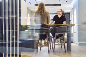 Ein Mitarbeiter von Prediger Lichtberater sitzt an einem Tisch im Showroom und führt eine Besprechung mit einer Kundin. (Foto: Johannes Arlt)