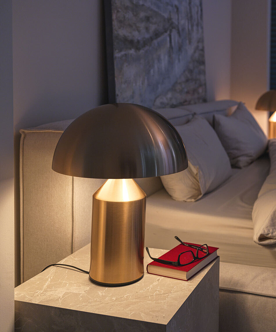 Schlafzimmer mit zwei goldenen Atollo Tischleuchten als Nachttischleuchten von der Marke Oluce.