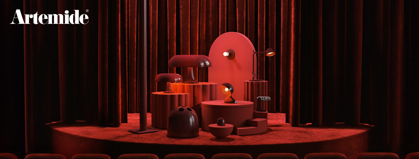 Bühnenartige Inszenierung der Artemide Ruby Red Collection: Mehrere Designleuchten in verschiedenen Größen sind auf roten Podesten vor einem dunkelroten Samtvorhang arrangiert. Die Szene ist vollständig in Rot- und Dunkelrottönen gehalten und wird atmosphärisch beleuchtet. Links oben befindet sich das Artemide-Logo. Bild: Artemide – © Pezzo di Studio
