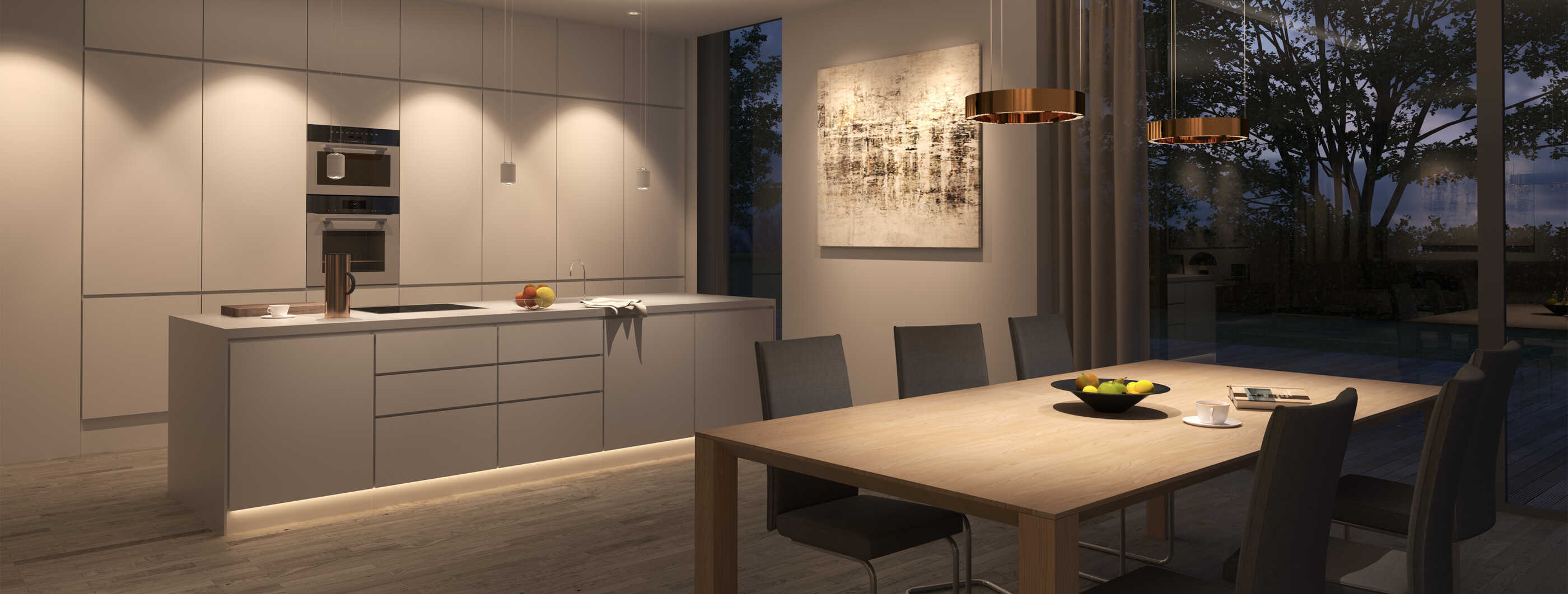 Eine moderne, offene Küche mit zentralem Tresen als Arbeitsfläche, im Vordergrund ist der Esstisch zu sehen. Downlights beleuchten die Küchenschränke, eine Lichtleiste dient der Sockelbeleuchtung des Tresens.