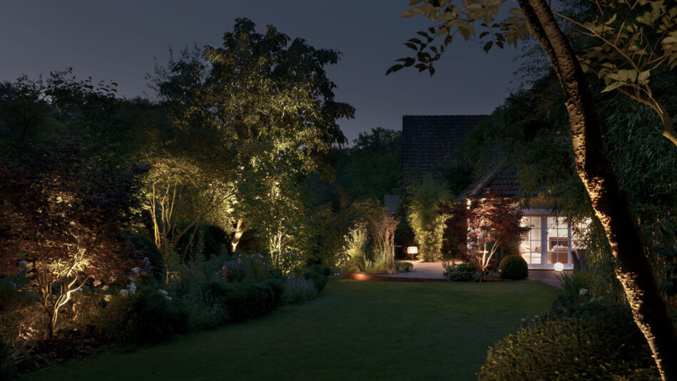 Ein Garten bei Nacht: Indirekt ausgerichtete Bodenstrahler sorgen für Lichtakzente in der Vegetation, eine diffus-allgemein strahlende Tischleuchte sorgt auf der Terrasse für Helligkeit. (Foto: Prediger Lichtberater)