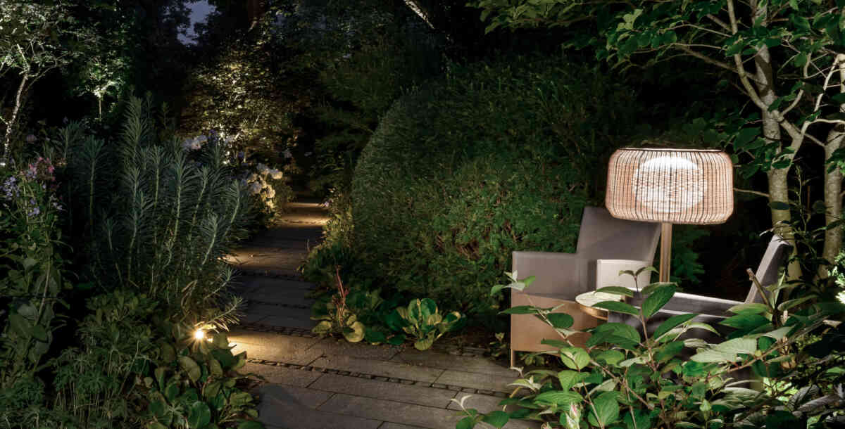 Eine Outdoorstandleuchte steht zwischen zwei Outdoor-Sesseln und inszeniert den Bereich als Ruhezone. (Foto: Prediger Lichtberater)