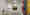 Der Flur einer Zahnarztpraxis in Berlin: Runde Deckenleuchten sorgen für eine ausgewogene Allgemeinbeleuchtung, an den Wänden hängen zahlreiche bunte Kunstwerke. (Foto: Prediger Lichtberater) imageThumbnailAlt